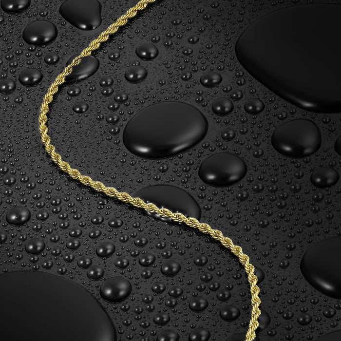 Gold rope chain on a textured black surface with water droplets