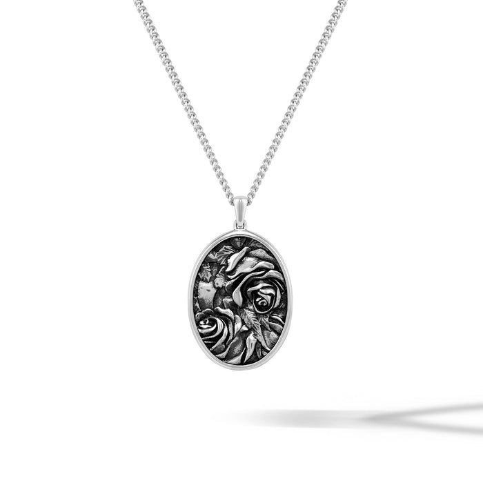 Silver necklace with an oval pendant featuring a rose design on a white background