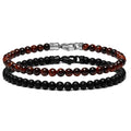 Two beaded bracelets, one with black onyx beads and one with red tiger eye beads, laid out next to each other.