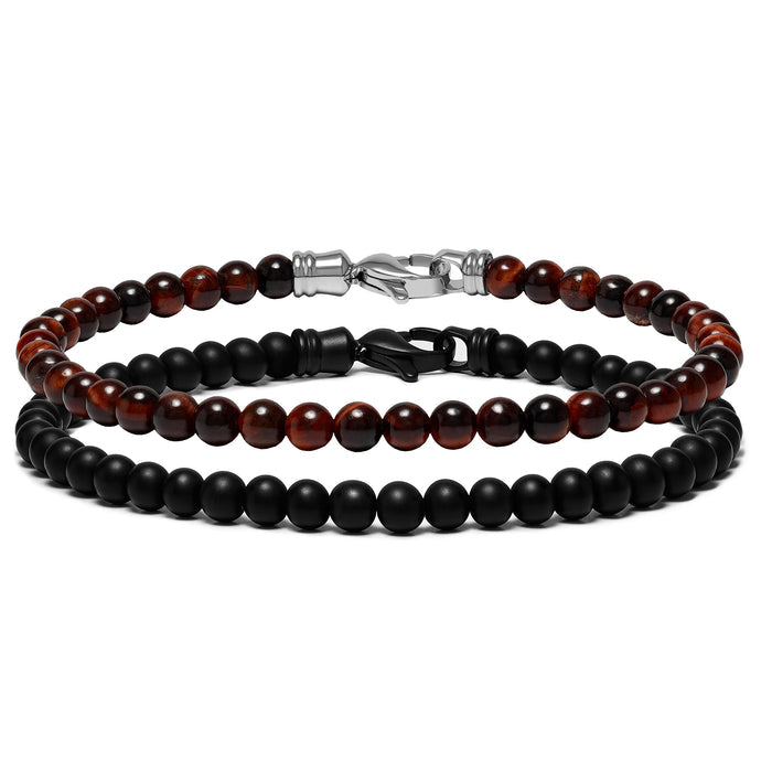 Two beaded bracelets, one with black onyx beads and one with red tiger eye beads, laid out next to each other.