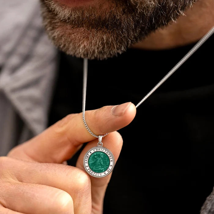 Person holding a necklace with a green pendant