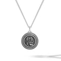 Silver necklace with a round pendant on a white background