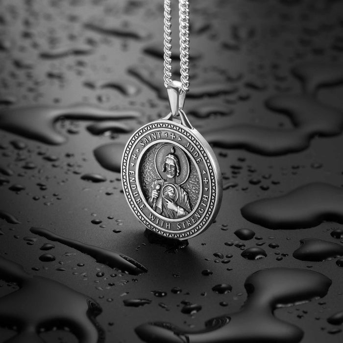 Silver pendant necklace on a dark, water-textured background