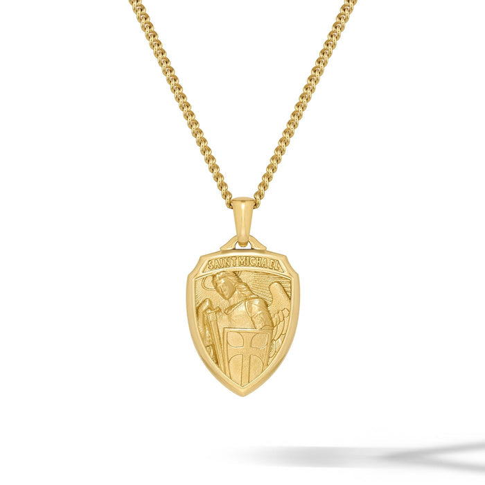 Gold necklace with a shield-shaped pendant on a white background