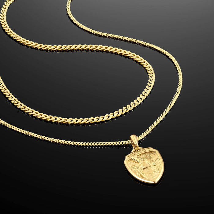 Gold necklace with a shield-shaped pendant on a black background