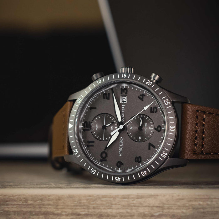 Watch with a brown leather strap on a wooden surface