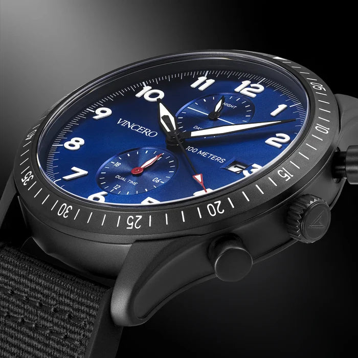 Watch with blue dial and black strap on a dark background