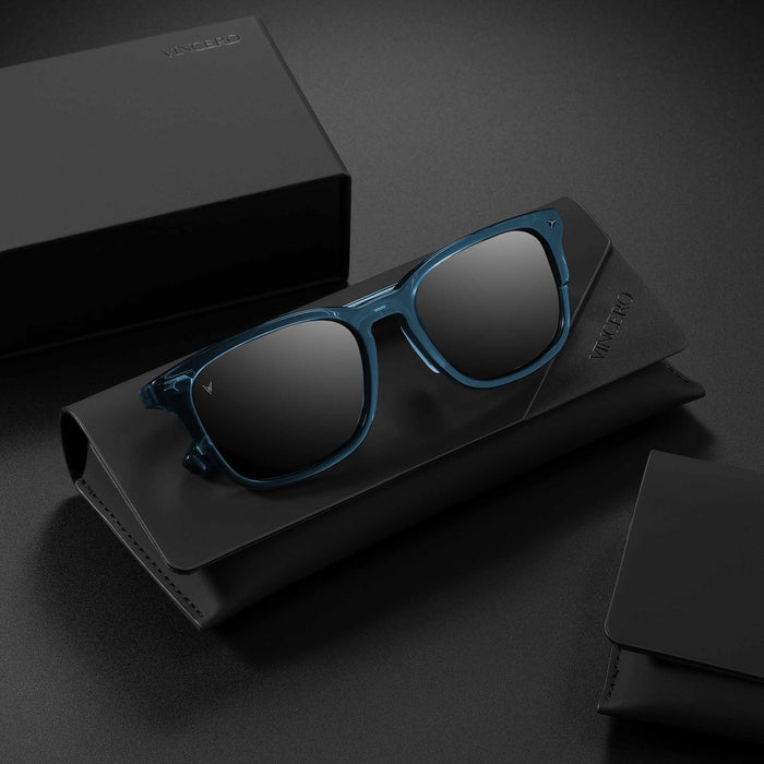 Blue sunglasses on a black stand with a dark background