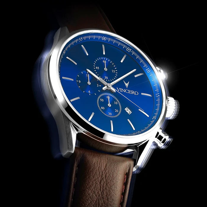 Watch with blue dial and brown leather strap on a dark background