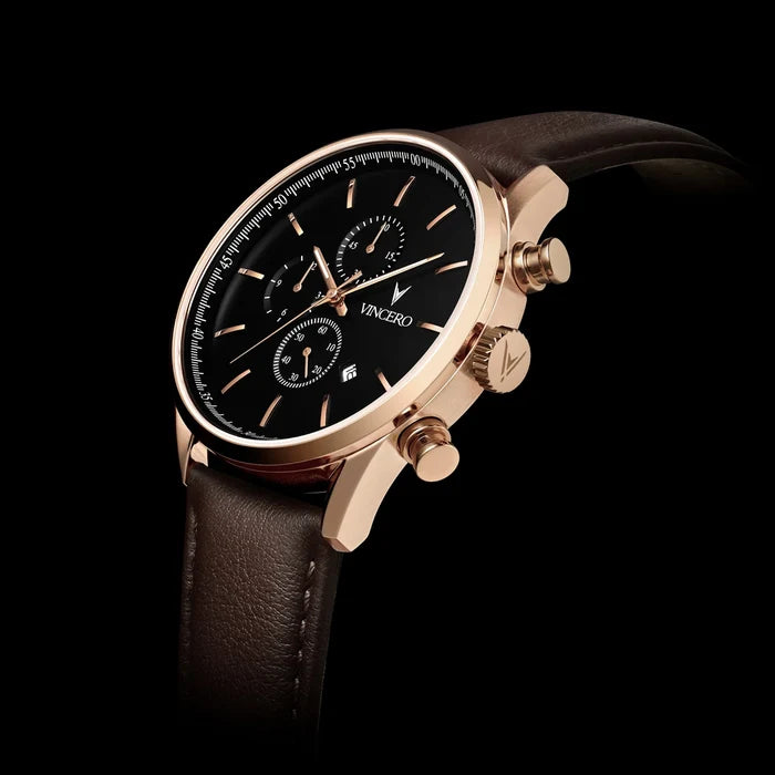Luxury watch with brown leather strap and rose gold case on black background