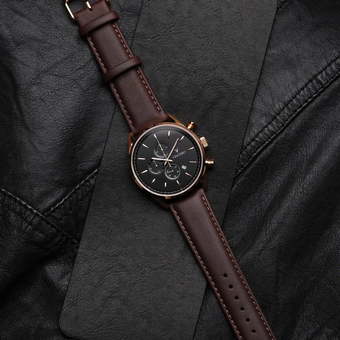 Watch with brown leather strap on a black textured surface
