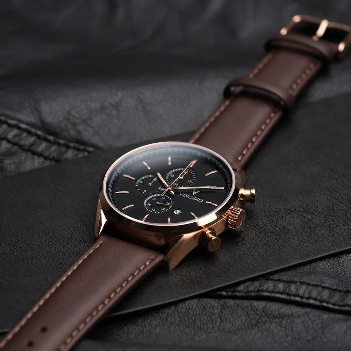 Watch with brown leather strap on a dark textured surface