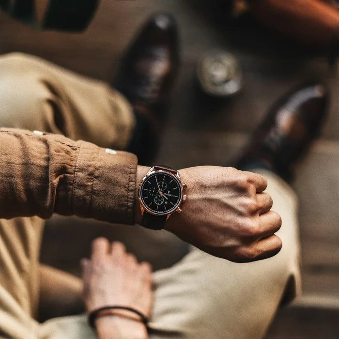 Close-up of a person's wrist wearing a watch with a blurred background