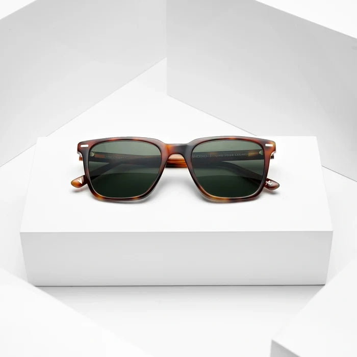 Sunglasses with tortoiseshell frame and dark lenses on a white background