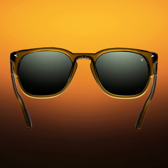 Sunglasses with a brown frame and dark lenses on an orange gradient background