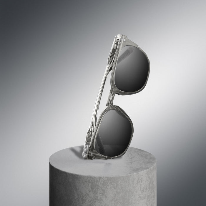 Sunglasses on a gray pedestal against a gradient gray background