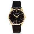A Vincero dress watch with a black leather strap, gold case, and black dial with gold accents, including gold hour markers and a gold second hand. The watch shows a date display.