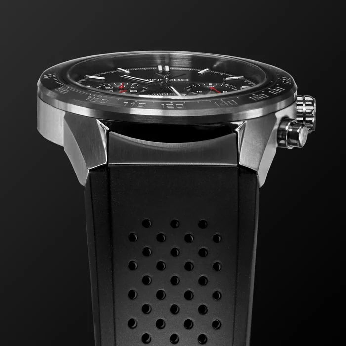 Close-up of a black wristwatch with a detailed face on a dark background