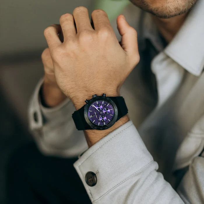 Person wearing a watch with a purple face on a blurred background