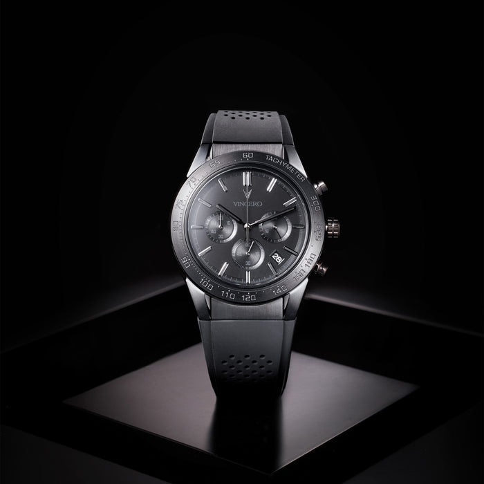Black wristwatch with detailed face on a black background