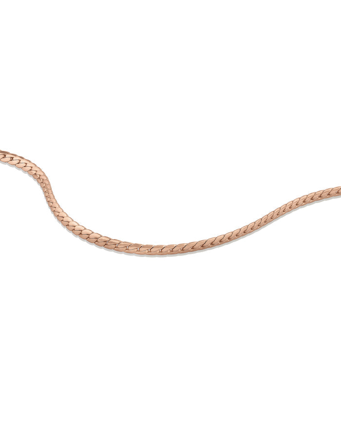 Serpentine rolls gold woman's bracelet on white.