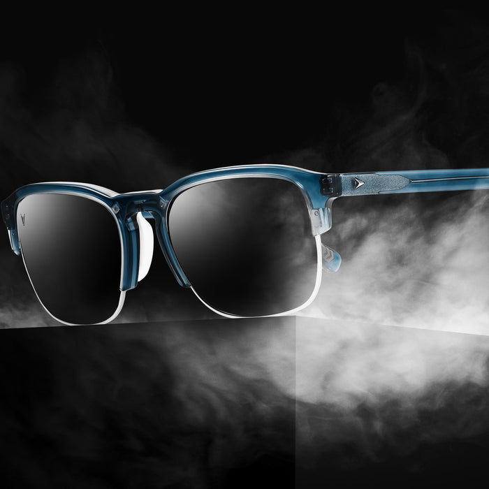 Blue sunglasses with dark lenses on a black background with smoke effect