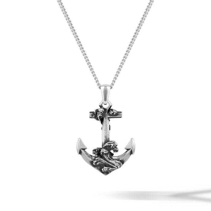 Silver anchor pendant with wave design on a white background