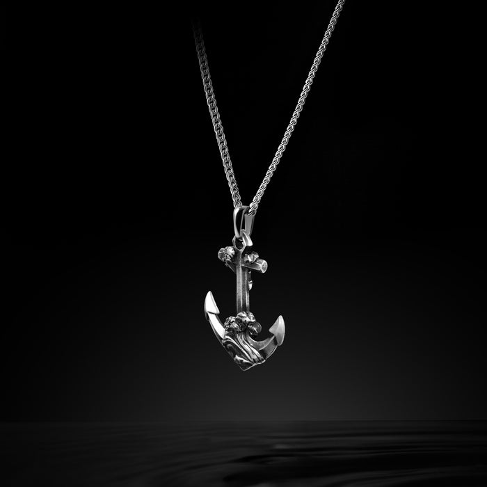 Silver anchor pendant necklace on a black background