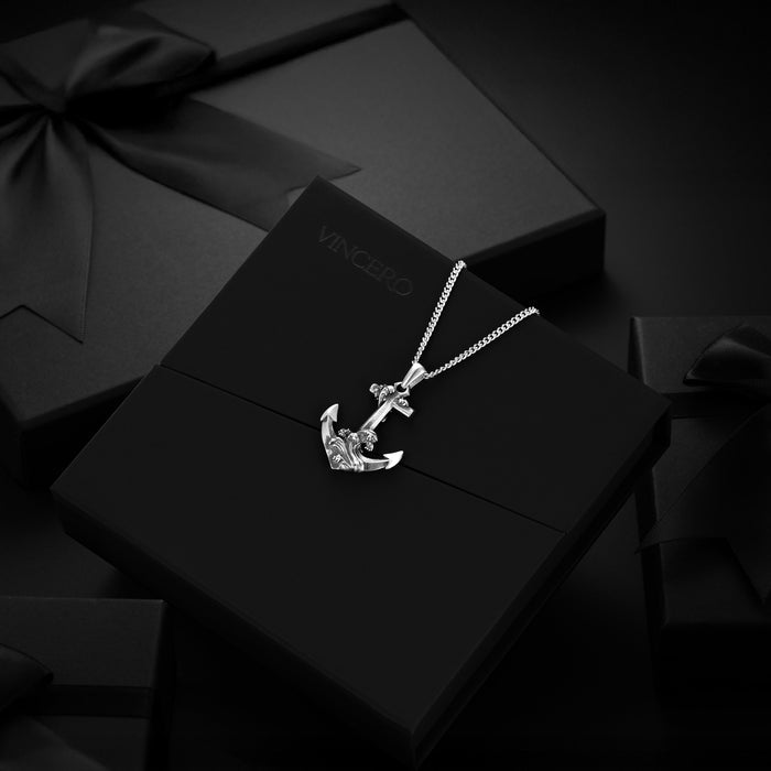 Silver anchor necklace on a black box with 'VINCENT' branding