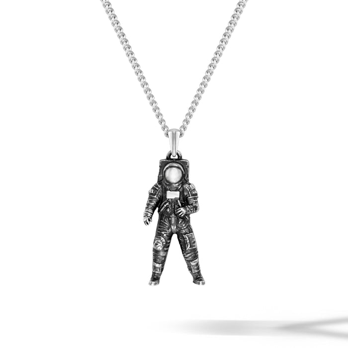 Astronaut pendant on a chain against a white background