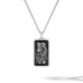 Silver pendant with intricate design on a white background