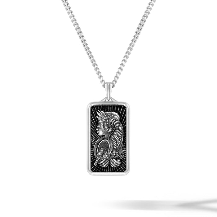 Silver pendant with intricate design on a white background