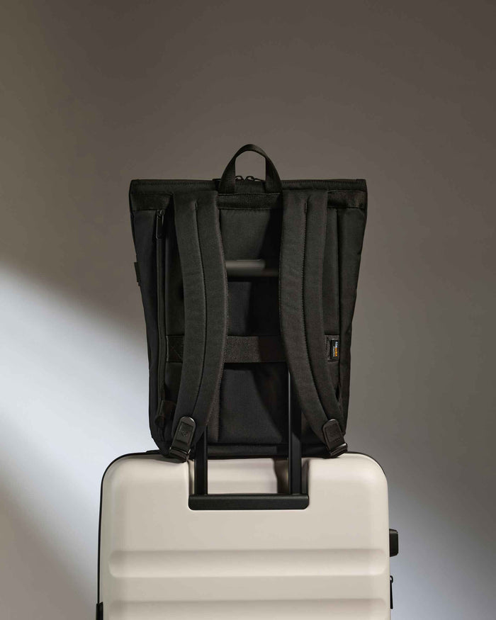 a black backpack on a white suitcase