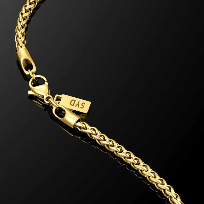 Gold chain bracelet with a clasp on a black background